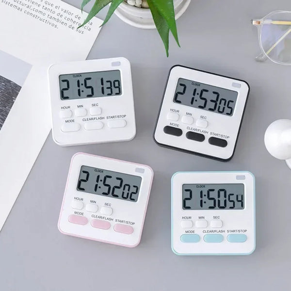 Drei weiße und schwarze digitale Küchentimer zeigen verschiedene Zeiten auf einer grauen Oberfläche.