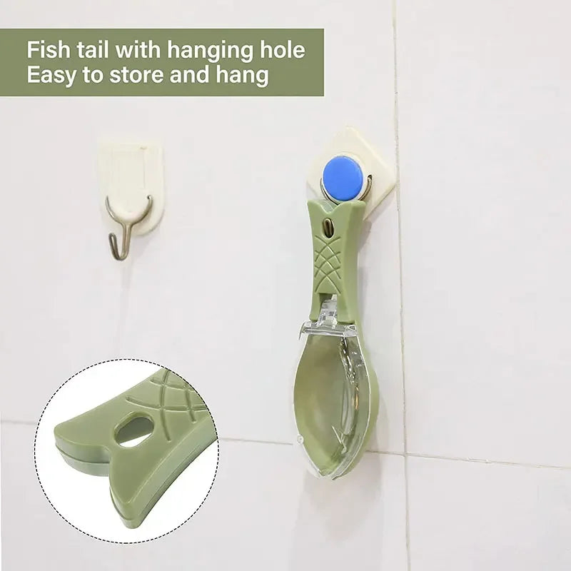 A light green fish tail scraper with a hanging hole and cleaning brush set mounted on a white tile.