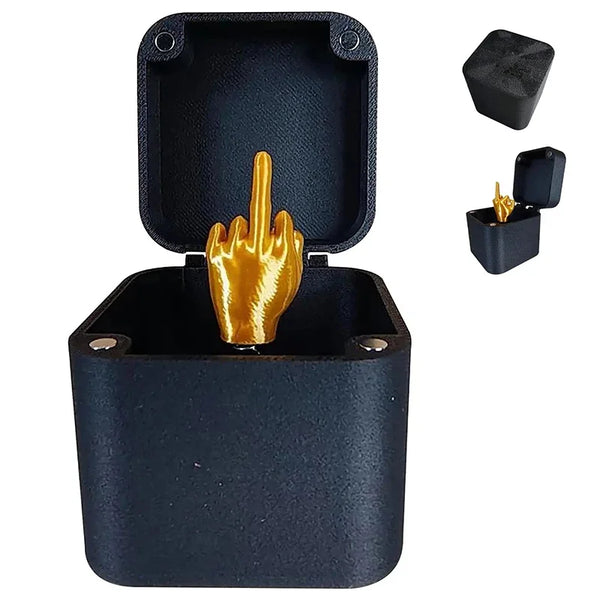 A dark blue gift box containing a golden middle finger prank item and an accessory tool.