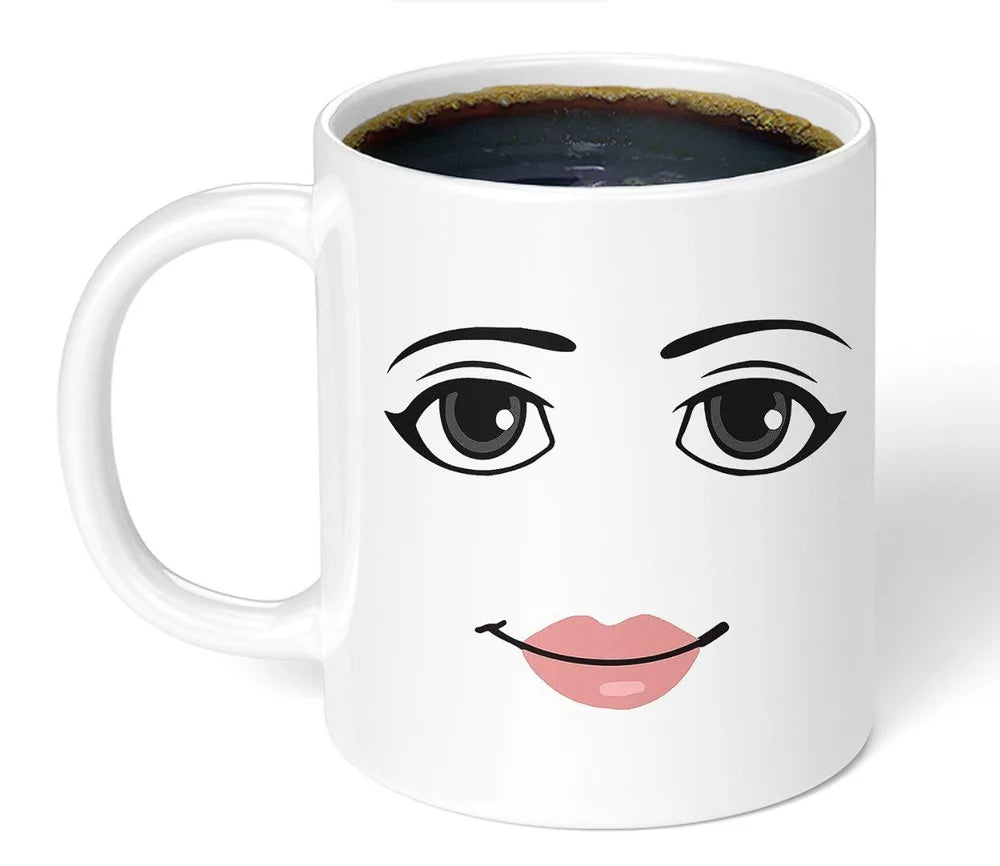 A white ceramic coffee mug featuring a stylized black line drawing of an expressive face with large eyes and pink lips.