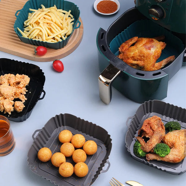 Wiederverwendbare Silikon-Airfryer-Einsatzform mit gebratenem Hähnchen, Kartoffelstäbchen und goldenen Kugeln