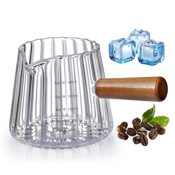 Klares Glasmessbecher mit Henkeln, gefüllt mit Flüssigkeit, blauen Eiswürfeln und Kaffeebohnen.