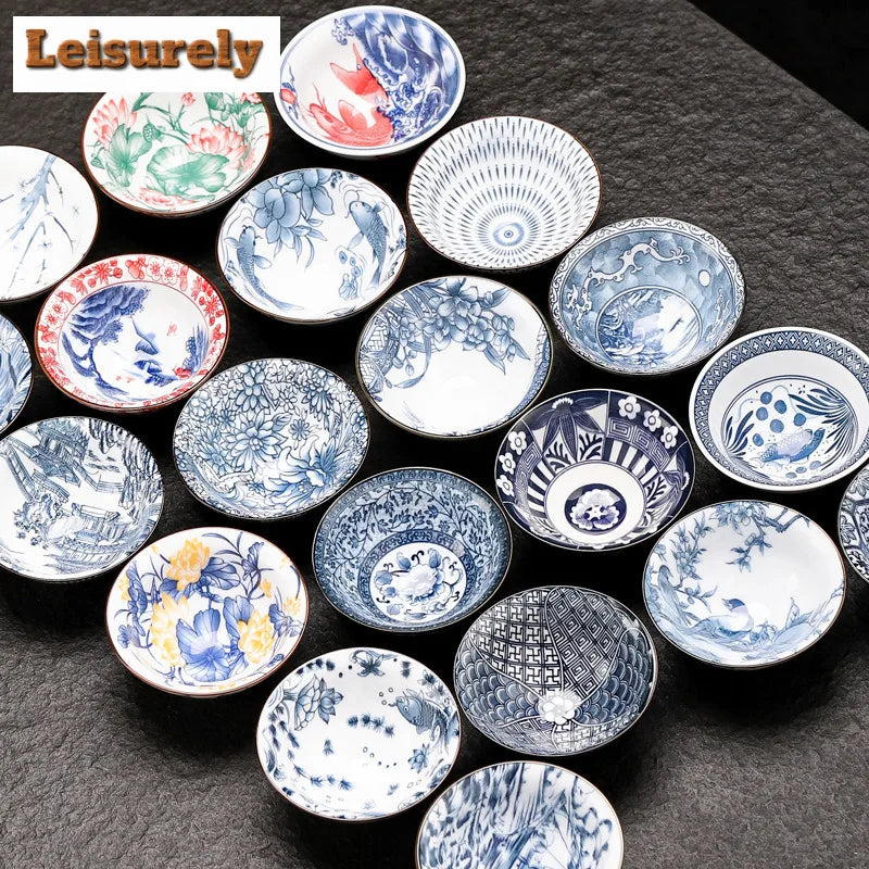 A collection of handmade blue and white porcelain dishes and bowls arranged on a dark surface.