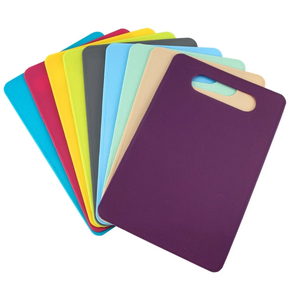 A set of colorful plastic cutting boards stacked in a row, featuring shades of green, yellow, blue, and purple.