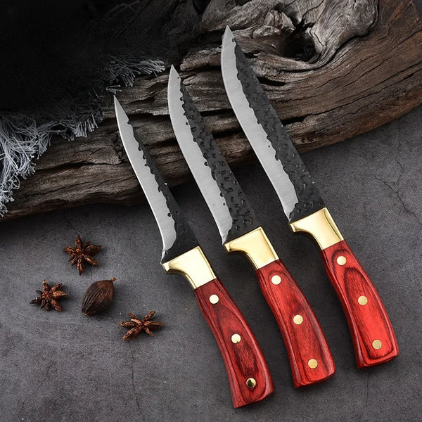 Ein Set aus drei geforgten Boning-Messer mit Edelstahlklingen und Holzgriffen auf einer dunklen Steinoberfläche.