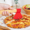 A hand is using a red axe-shaped pizza cutter to slice a pizza on parchment paper.
