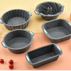 A collection of gray silicone baking molds, including muffin cups and cake pans, displayed on a light background.