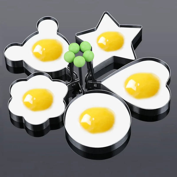 Set aus Edelstahl-Eierformern und Pfannkuchenformen mit gelben Eiern und grünen Kugeln.