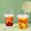 Two plastic cups filled with iced tea and fruit slices are displayed on a light green surface.