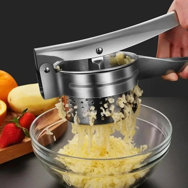 Eine Hand bedient eine leistungsstarke Edelstahl-Gemüsegemühle, die Saft in eine Glasschale extrahiert.