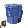 A blue novelty trash can with a lid and a recycling symbol, shown next to a black coffee mug.