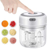 A hand is shown pressing a button on a clear electric mini food chopper and grinder device.