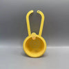 A yellow press-type drain basket with a curved handle is shown against a gray background.
