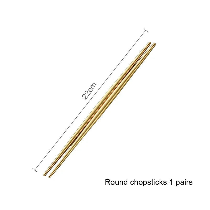 A pair of round chopsticks made of matte gold stainless steel, shown diagonally.