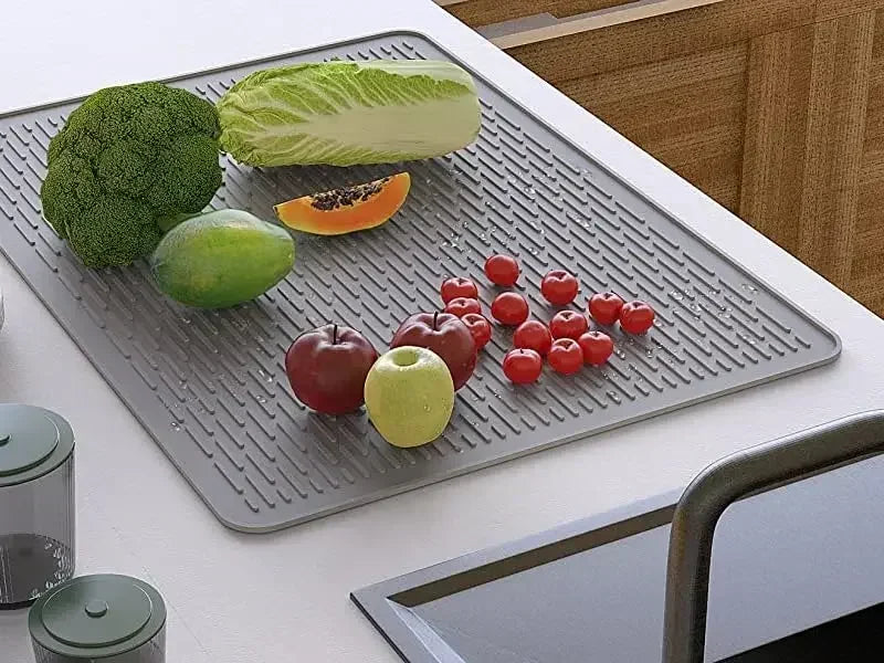 A silicone stove and cooktop protector mat displaying various fresh fruits and vegetables.