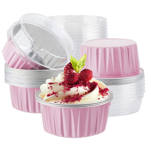 A stack of pink and white reusable aluminum foil baking cups with lids, some filled with whipped cream and berries.