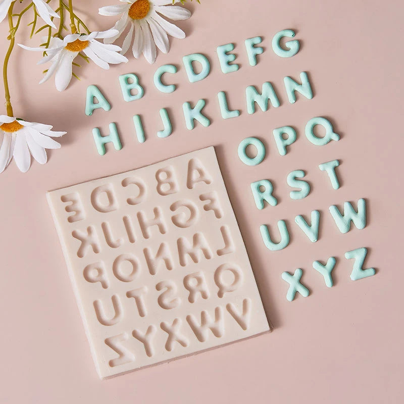 A silicone alphabet cake decoration mold with letters A through Z is displayed on a pink background.