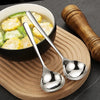 A stainless steel soup ladle with a long ergonomic handle rests on a wooden board next to a bowl of sliced vegetables.