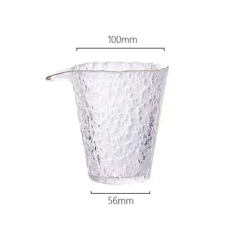 A clear glass teapot or pourer with a spout, measuring 100mm in height.