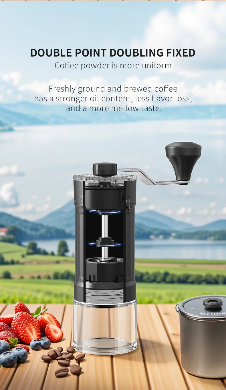A manual ceramic coffee grinder is shown on a wooden surface with fresh coffee beans and strawberries in the background.