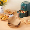 Reusable silicone baking liners in various colors and shapes displayed next to a teal air fryer.