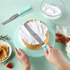 Hands are decorating a cake with white frosting using a metal knife and a turntable on a light green surface.