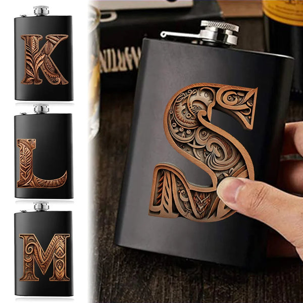 Dunkelgraue Edelstahlflasche mit erhabenem 'S'-Design und kunstvollen Mustern.