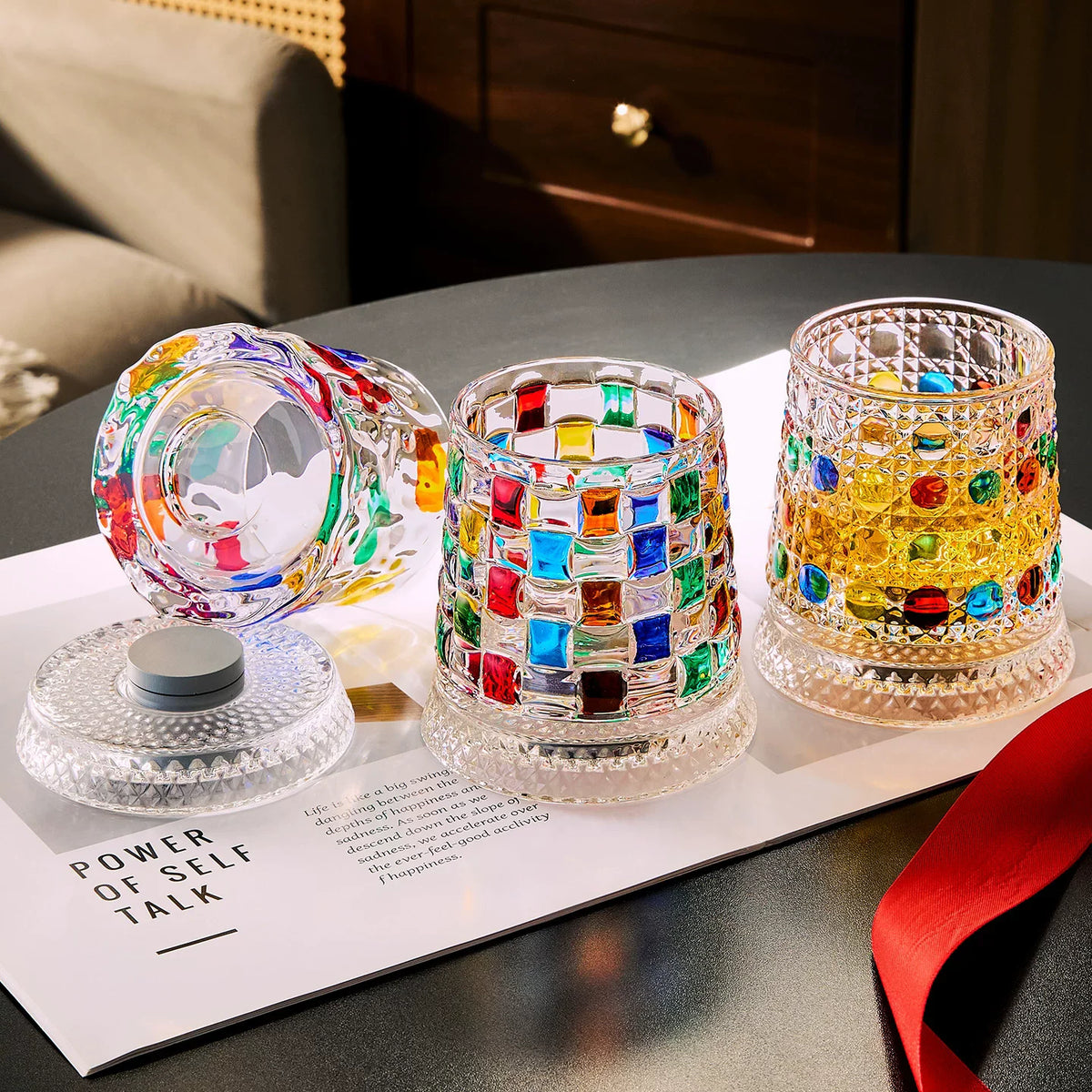 A set of rotating whiskey glasses with colorful glass patterns displayed on a white card.