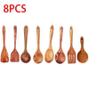 A set of ten natural teak wooden cooking spoons and spatulas arranged in a row.