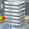 A stack of seven rectangular stainless steel food storage containers on a light surface.
