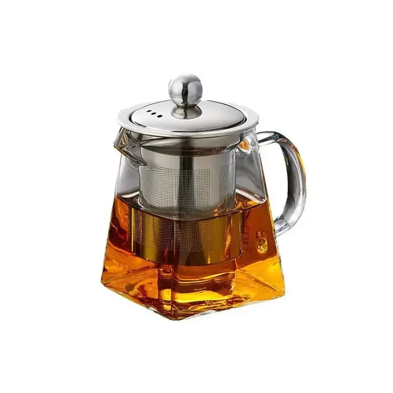 A heated glass teapot with a stainless steel infuser filled with amber-colored tea.