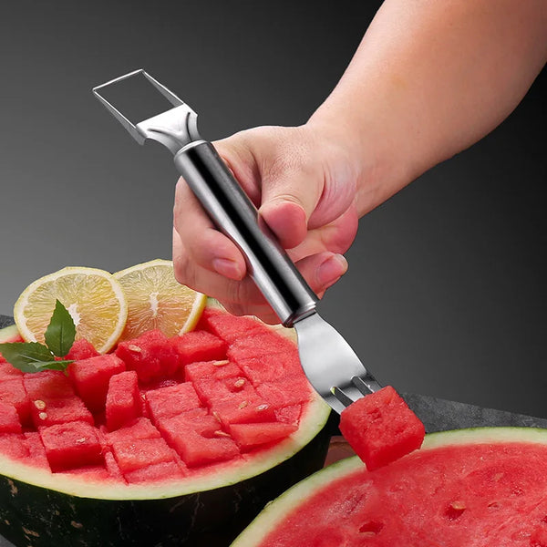 A hand holds a stainless steel watermelon slicer, dividing and cutting a slice of watermelon.