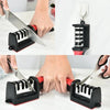 A hand is using a black and red handheld knife sharpener with tungsten steel to sharpen a knife.