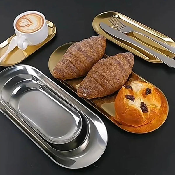 Ein Set eleganter Edelstahl-Dessertteller mit Croissant und Kaffeetasse.
