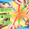 Hands are stirring an orange drink with colorful reusable beverage stirrers and straws.