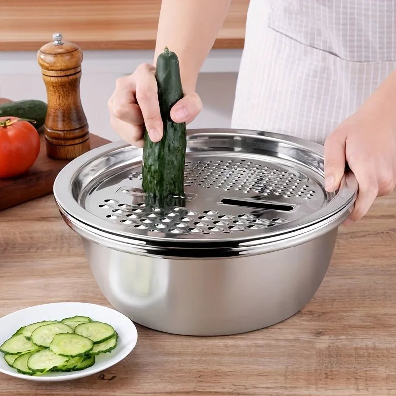 A hand is placing a cucumber into a stainless steel mixing bowl set with a grater and strainer.