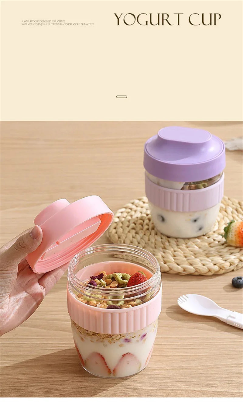 A glass yogurt cup filled with yogurt and fruit, next to a pink reusable lid and a stacked purple container.