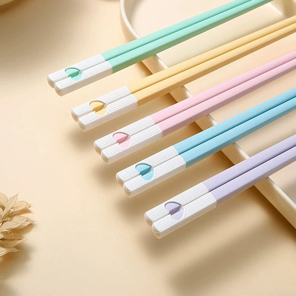 Ein Set wiederverwendbarer japanisch-chinesischer Bambus-Stäbchen in Pastellfarben wie Mintgrün, Beige, Pink und Lavendel.