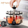 A hand is rotating a set of glass spice jars on a black rotating base for kitchen organization.
