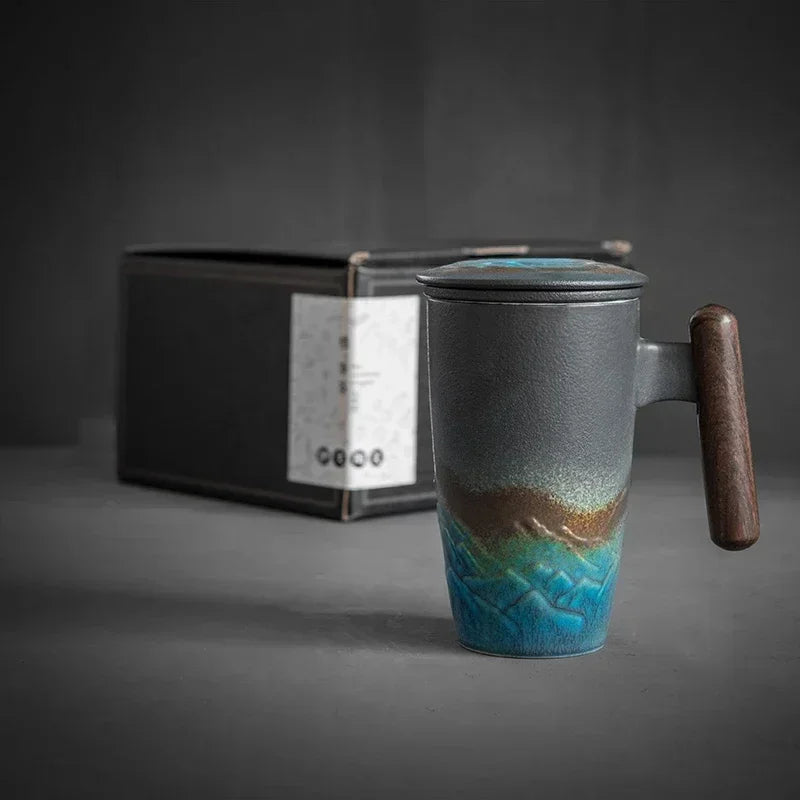 Taza de té de cerámica con tapa y asa de madera, con esmalte degradado azul y marrón.