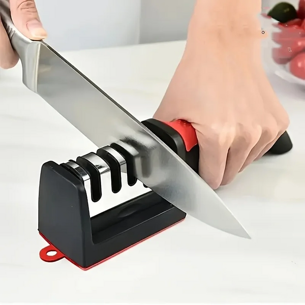 A hand is using a black knife sharpener with a silver blade to sharpen a knife.