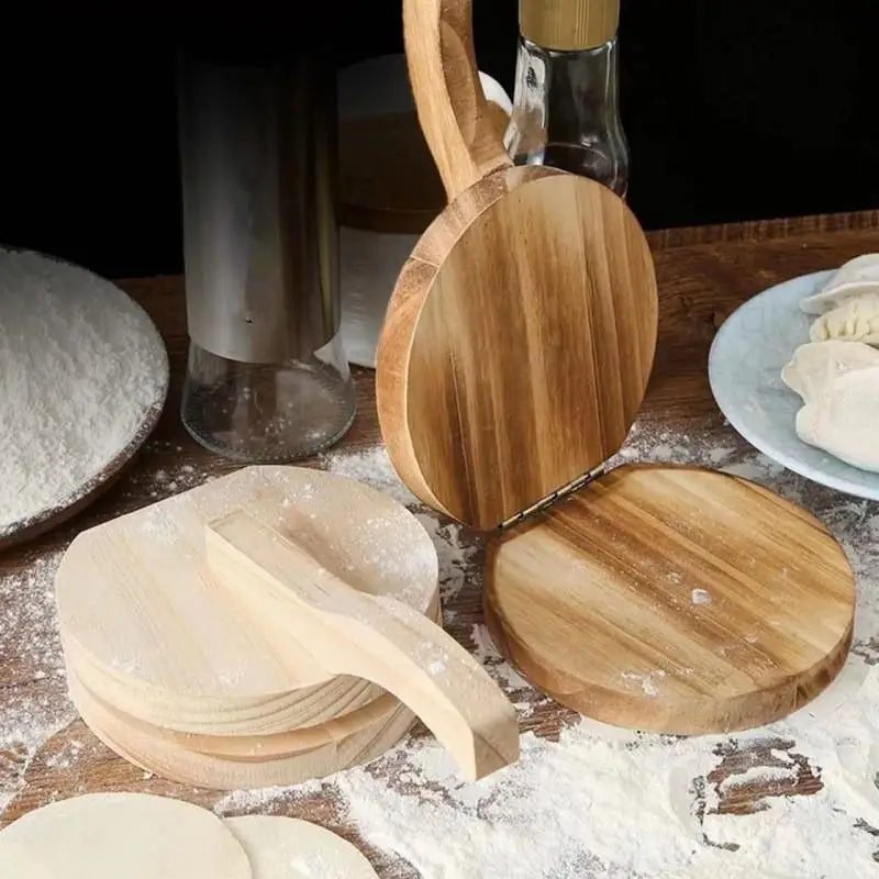 A solid wood dumpling press tool is shown with several wooden discs and a glass jar in a light, rustic setting.
