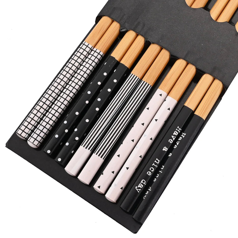 A set of reusable bamboo chopsticks in a black case with various sizes and patterns.