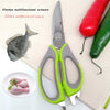 Un par de tijeras multifuncionales de cocina verdes brillantes y grises junto a un pescado, chiles y carne rosa
