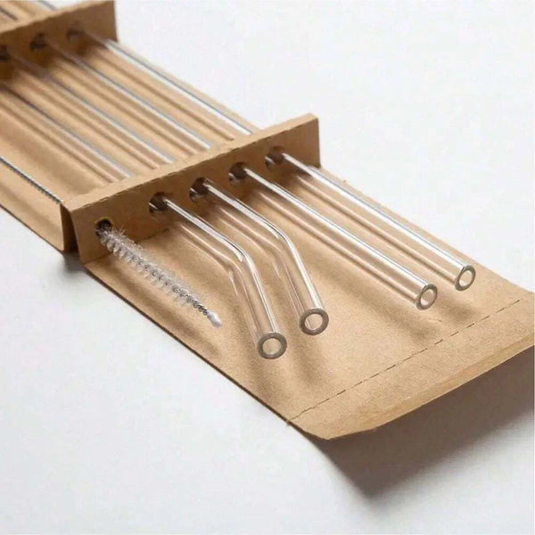 A set of reusable glass smoothie straws with cleaning brushes packaged in brown paper.