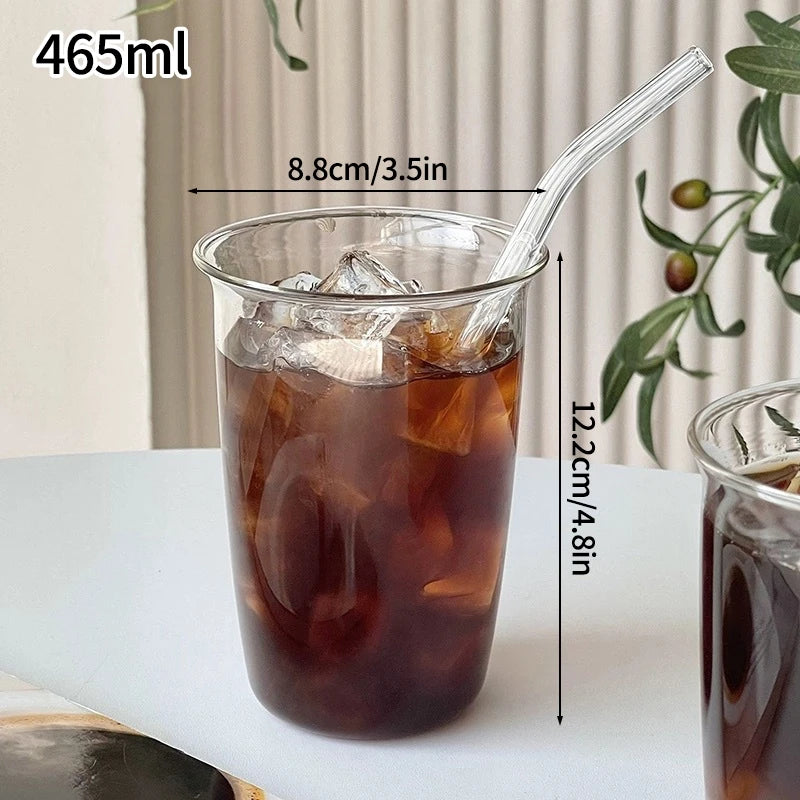 A tall glass tumbler filled with iced tea or a dark beverage, featuring a clear glass and a clear plastic straw.
