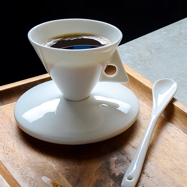 Weiße Porzellan-Kaffeetasse und Untertasse mit Löffel auf Holztablett.