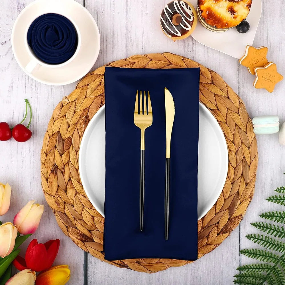 A set of ten navy blue satin dinner napkins displayed on a wooden platter with various food items.
