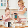 A woman is demonstrating a manual egg shell opener and beater on a wooden surface with eggs.