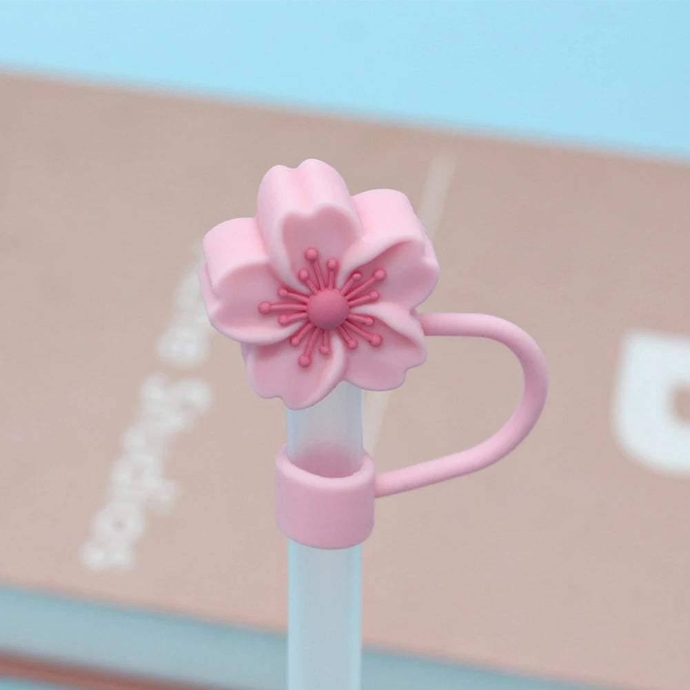 A pink flower straw cap is shown attached to a white tumbler straw.